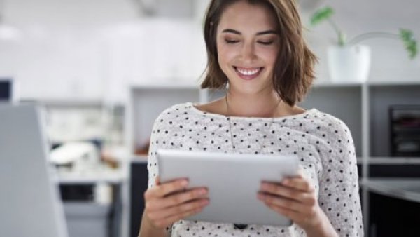 A women smiling looking down to an Ipad