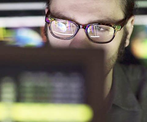 man with glasses behind the screen